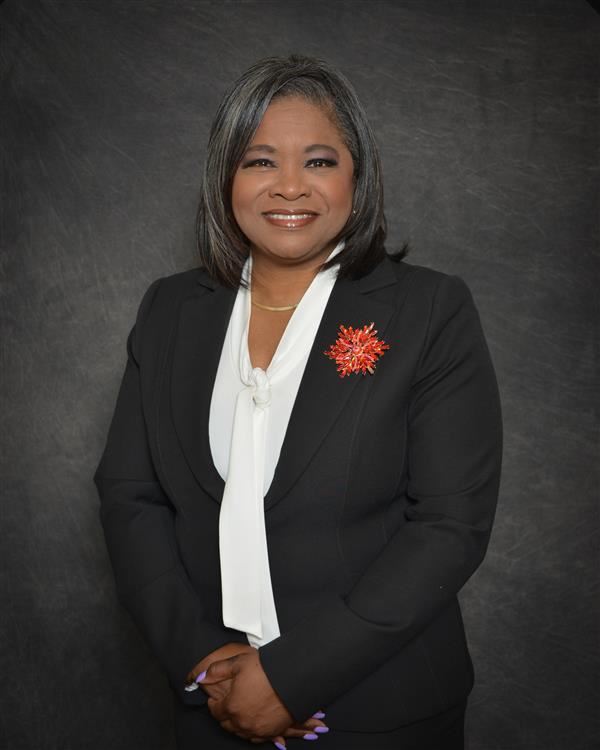 photo of dr. sherrod smiling with arms crossed against a gray background